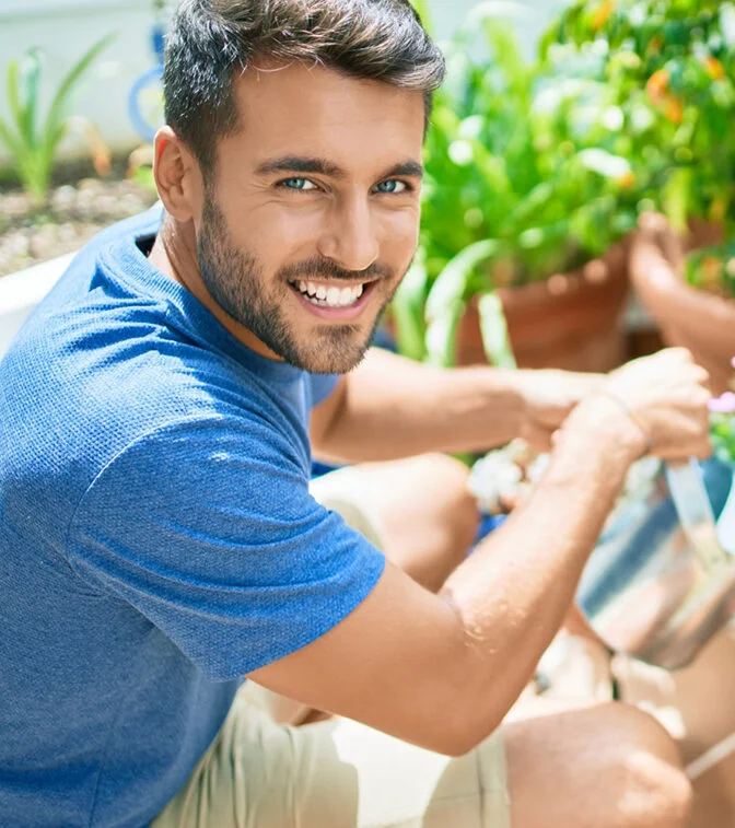 A man smiling while gardening