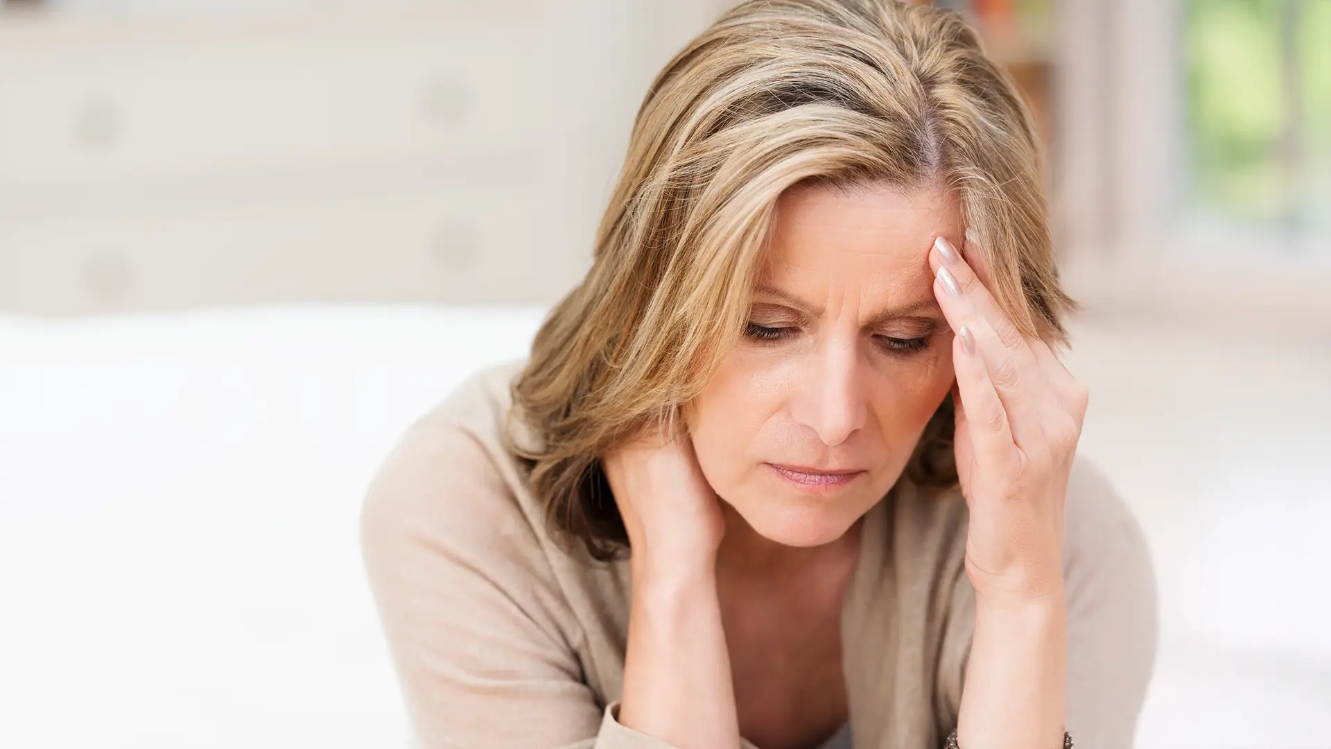 middle aged woman suffering and holding her neck and head