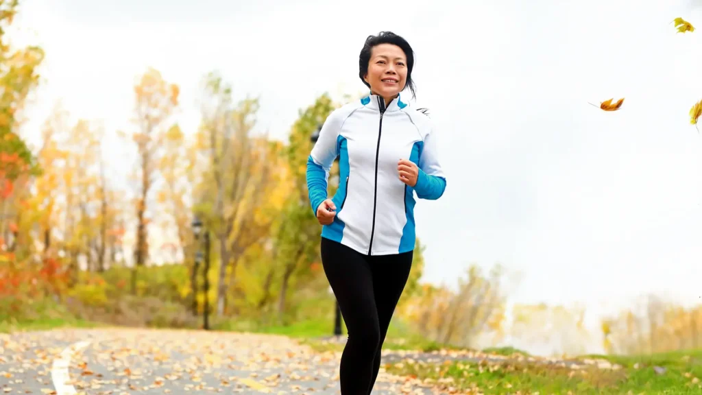 woman in her 50s running outside and smiling